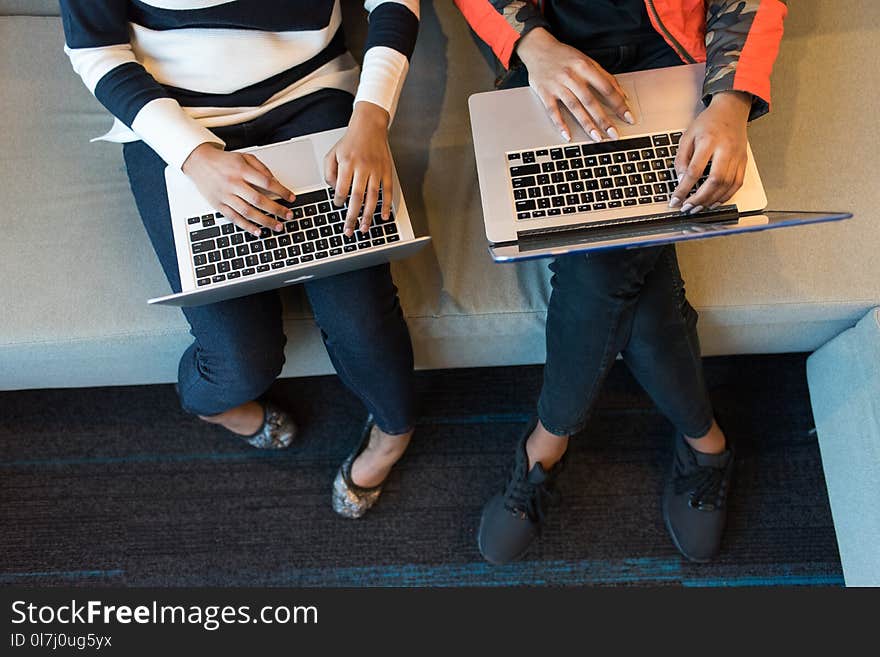 Two People Holding Macbook Pro