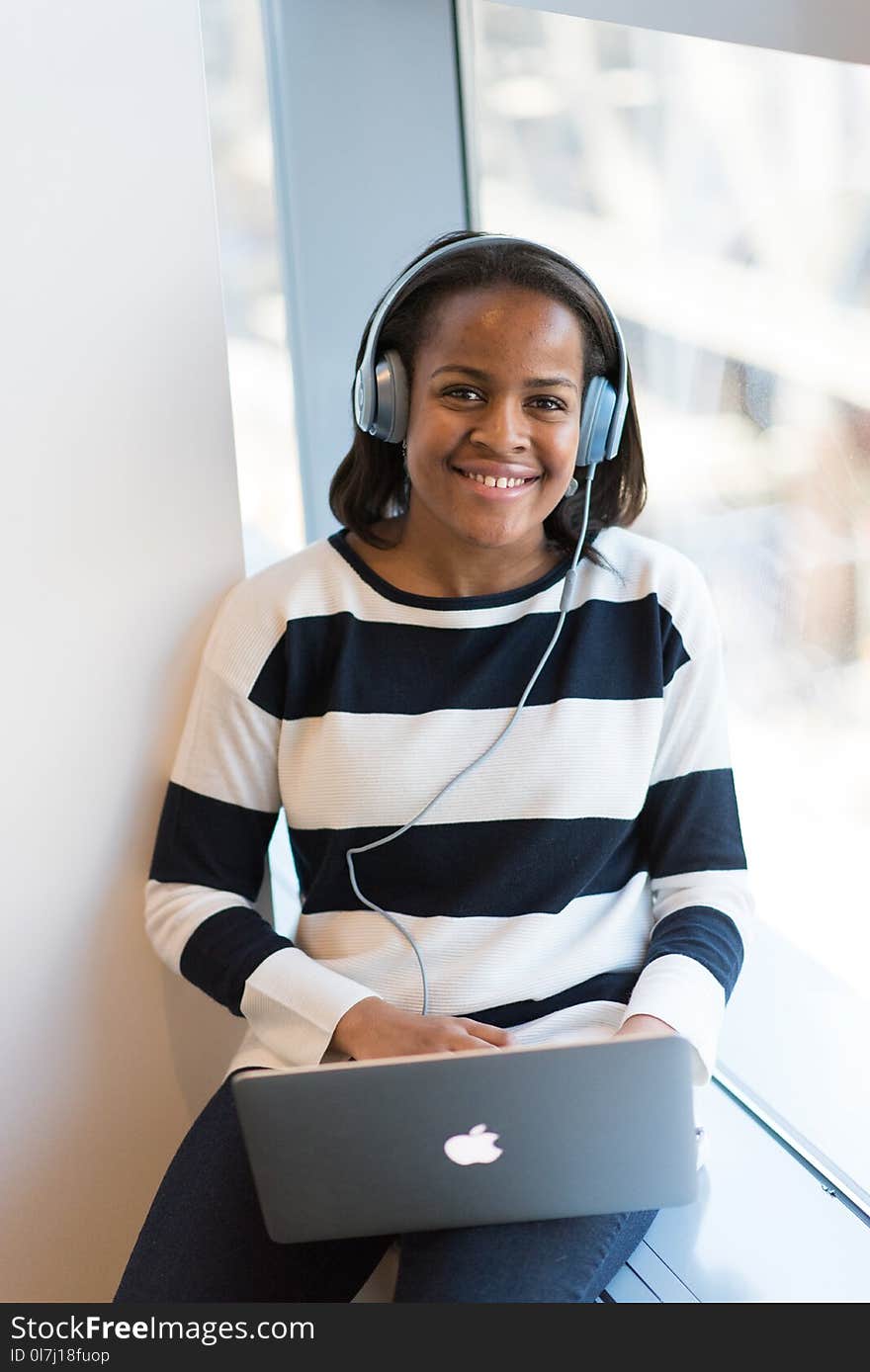 Woman Wearing White And Black Stripe Long-sleeved Shirt Holding Macbook