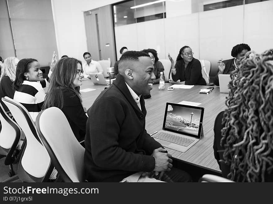 Group of People Sitting in Conference Table Laughing