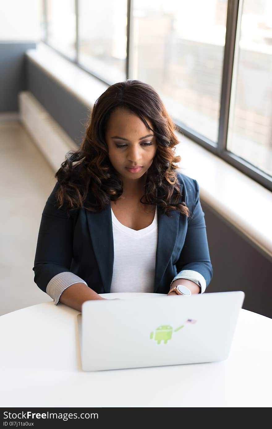 Tilt-shift Photography of Woman in Blue Formal Coat With White Laptop Computer