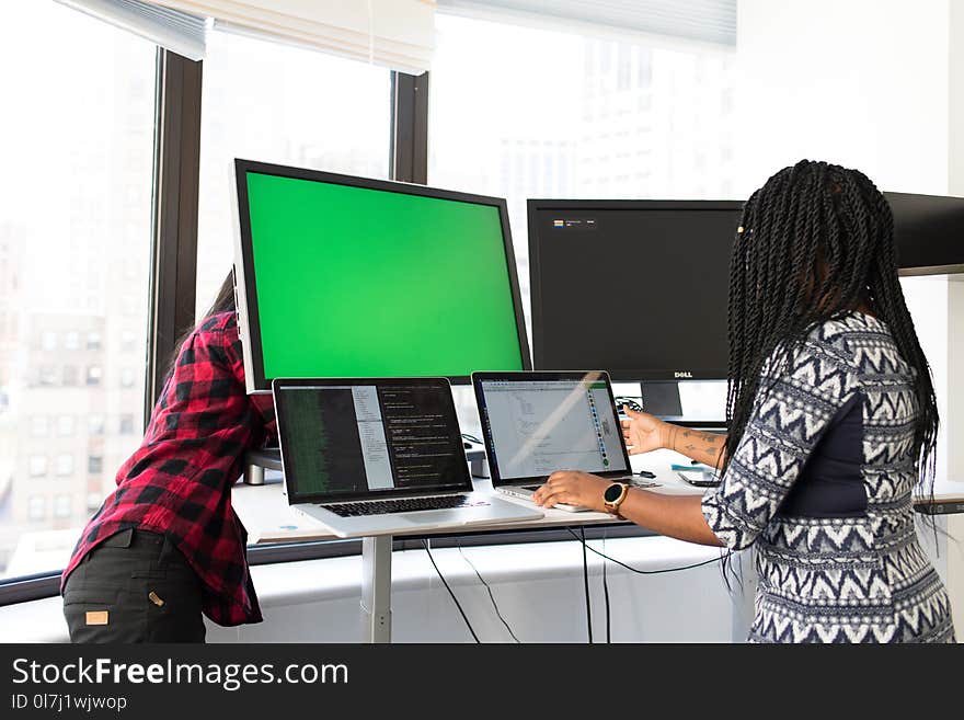 Woman Wearing White, Gray, and Black Elbow-sleeved Dress Using Macbook Pro