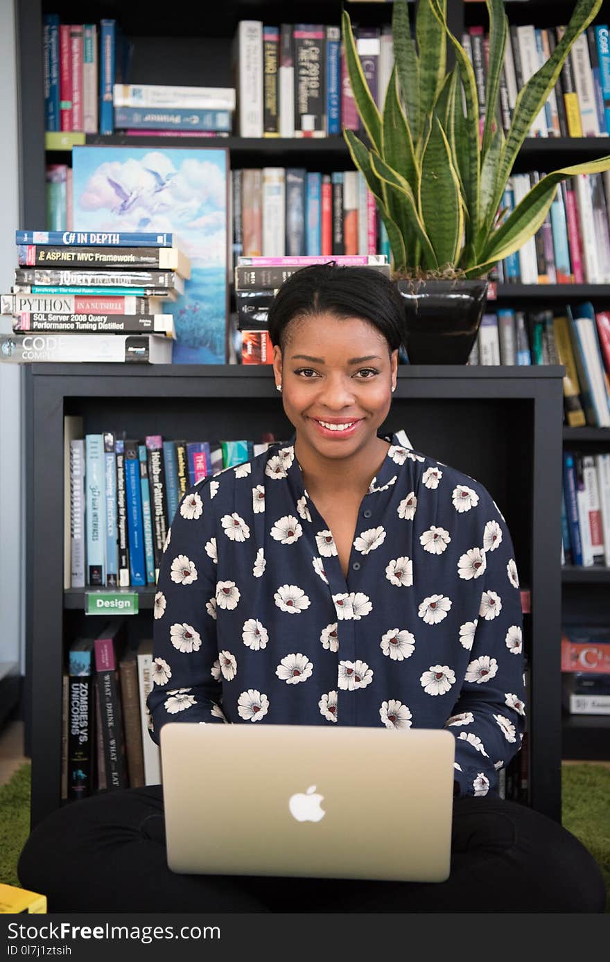 Woman in Black Floral Long-sleeved Top Near Book Shelves