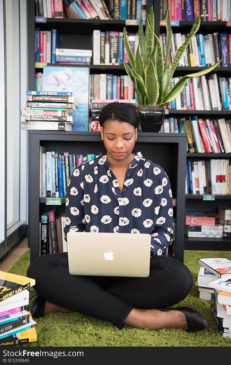 Woman Sits on Floor Facing Gold Macbook