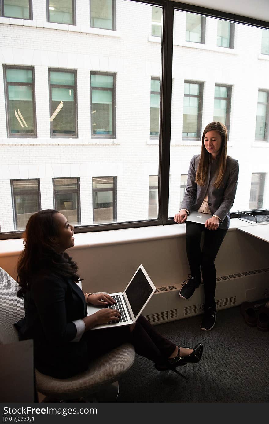 Two Women Talking White Holding Laptop Computers