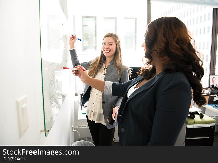 Two Women in Front of Dry-erase Board