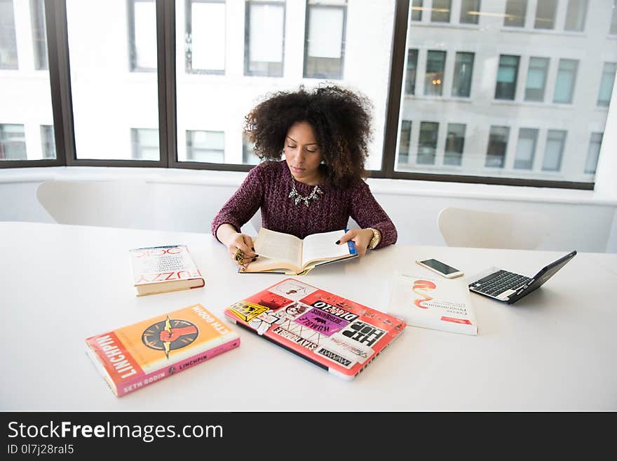 Woman Reading Book While Sitting