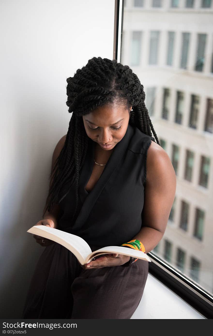 Woman Reading Book Leaning Near Wall