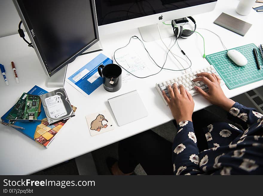 Person Typing on Corded Computer Keyboard Beside Apple Mighty Mouse