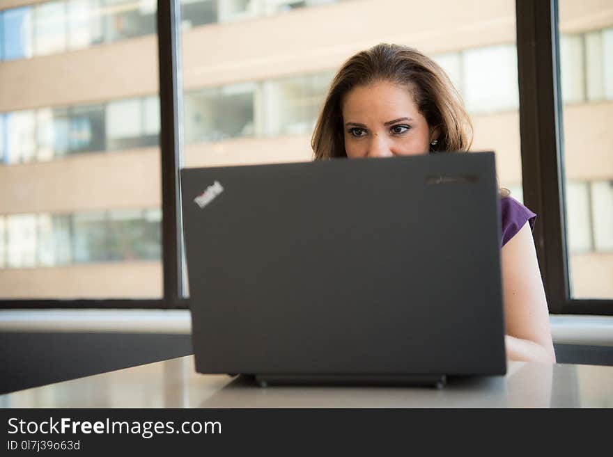 Woman Wearing Purple Top in Front of Lenovo Thinkpad