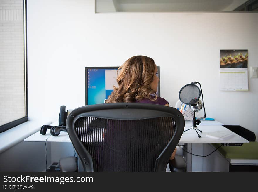 Woman Siting on Chair in Front of Turn on Computer Monitor