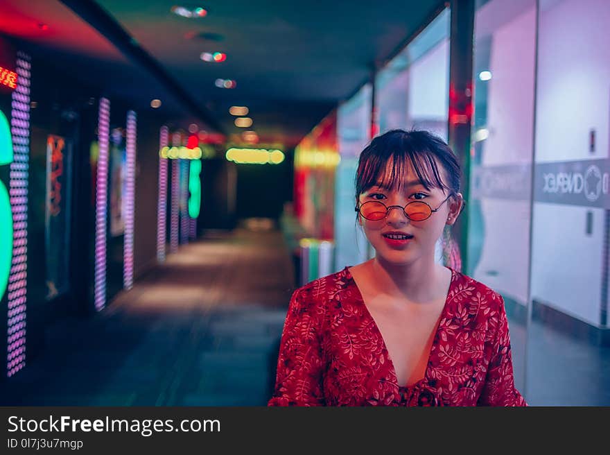 Woman Wearing Red Long-sleeved Top and Sunglasses on Hallway