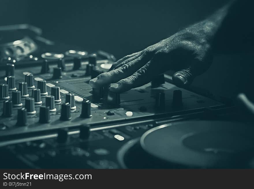 Disk Jockey mixer, stage equipment DJ mixing with the hand. Green tone