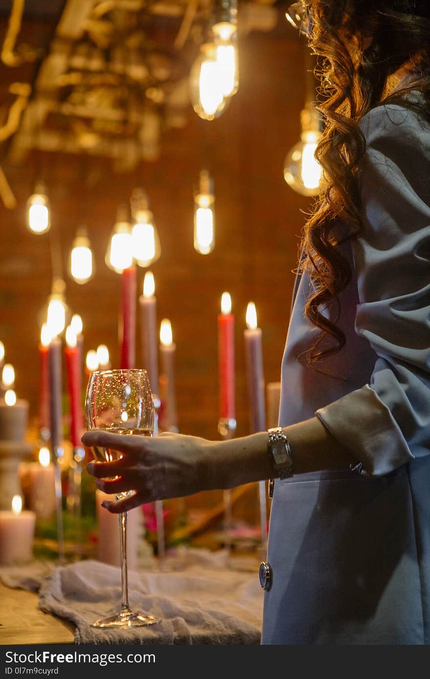 Woman standing neat wedding table, celebrate with a glass of win