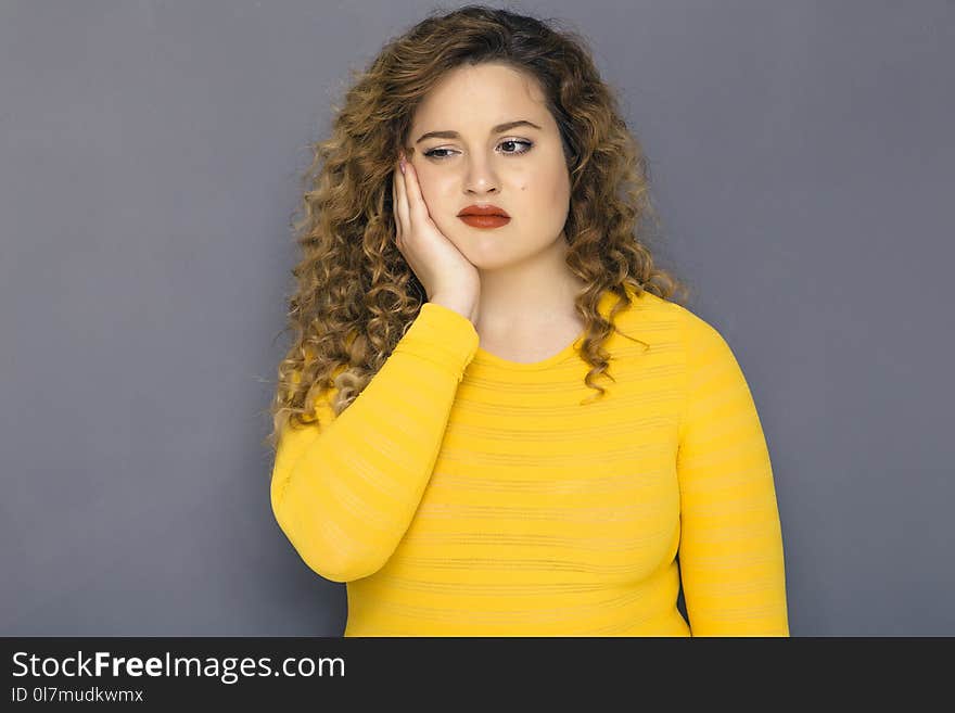 Cute Brunette Plus Size Woman With Curly Hair In Yellow Sweater