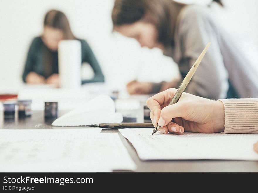 Woman learning lettering with brushes and calligraphic pen on a lesson in studio