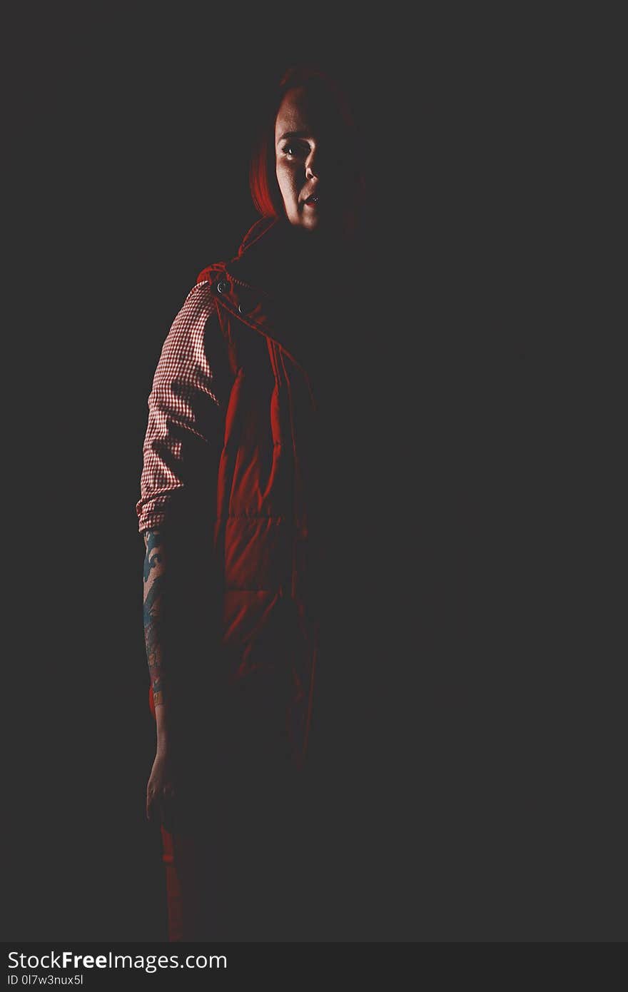 Red hair girl in dark studio with red color clothes, close portrait