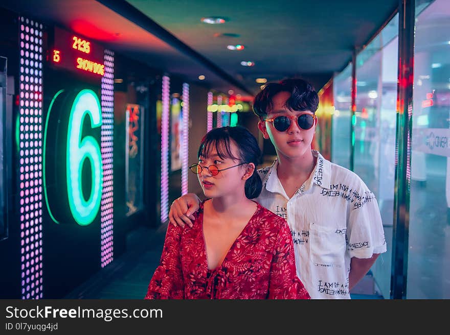 Man and Woman Standing on Hallway Surrounded by Led Lights