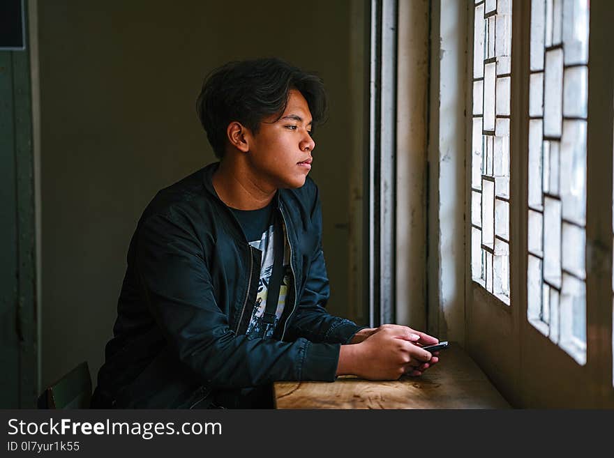 Man Beside Window Wearing Black Jacket