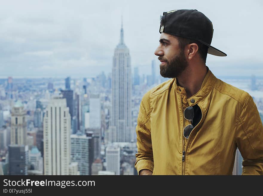 Portrait Photo of Man in Yellow Zip-up Jacket Near Empire State Building