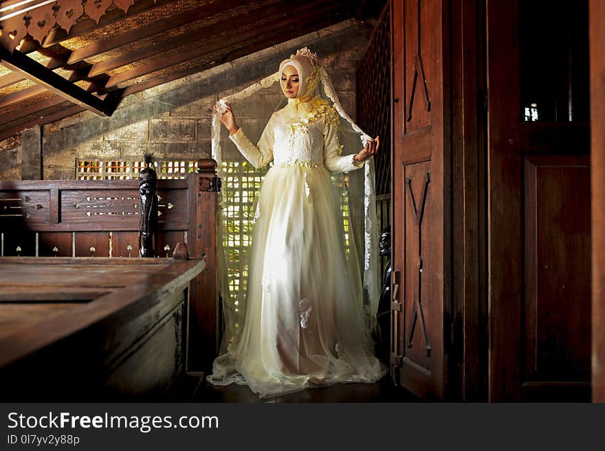 Women Wearing White Long-sleeved Dress Near Brown Wooden Door