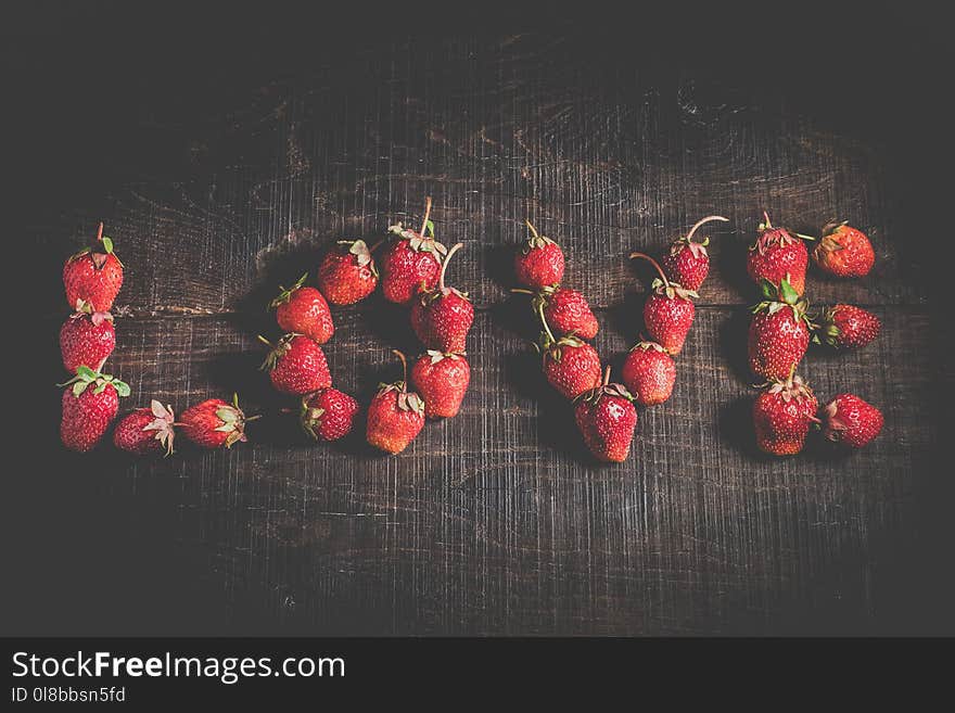 The inscription is love. Ripe strawberry fruit. Strawberries on a wooden background. Healthy food. Organic food. The idea of a postcard. Fruit on a wooden table. The inscription is love. Ripe strawberry fruit. Strawberries on a wooden background. Healthy food. Organic food. The idea of a postcard. Fruit on a wooden table.