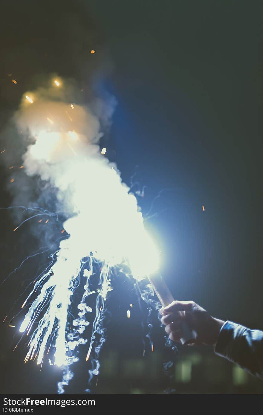 cropped view of male hand with smoke bomb with sparks