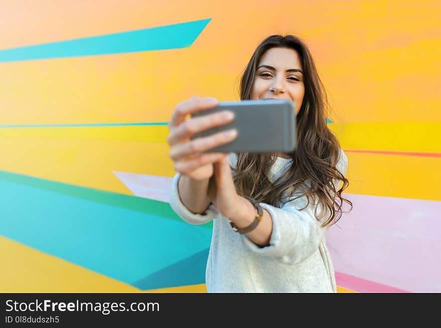 Hipster woman taking selfie photos in colorful abstract background. Hipster woman taking selfie photos in colorful abstract background