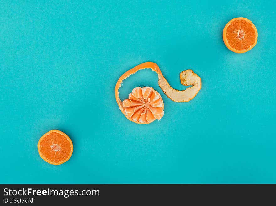 top view of arranged ripe mandarin and orange pieces isolated on blue