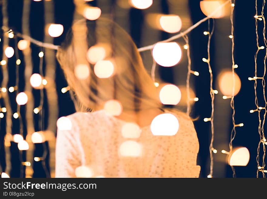 back view of woman with christmas light around on black