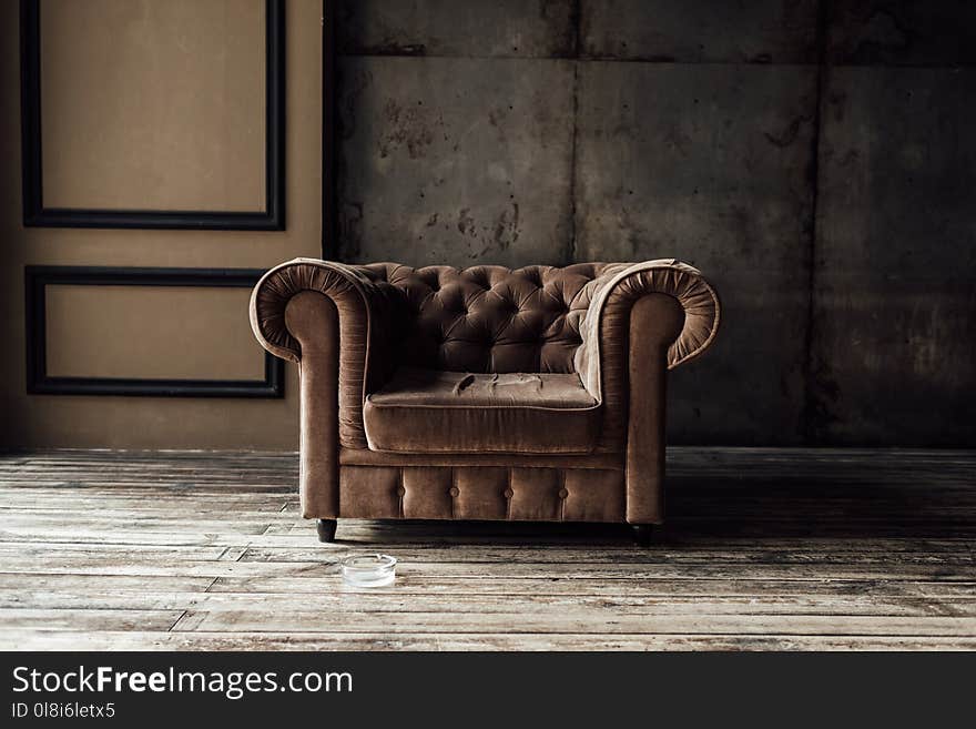 luxurious brown armchair and ashtray on floor in loft interior