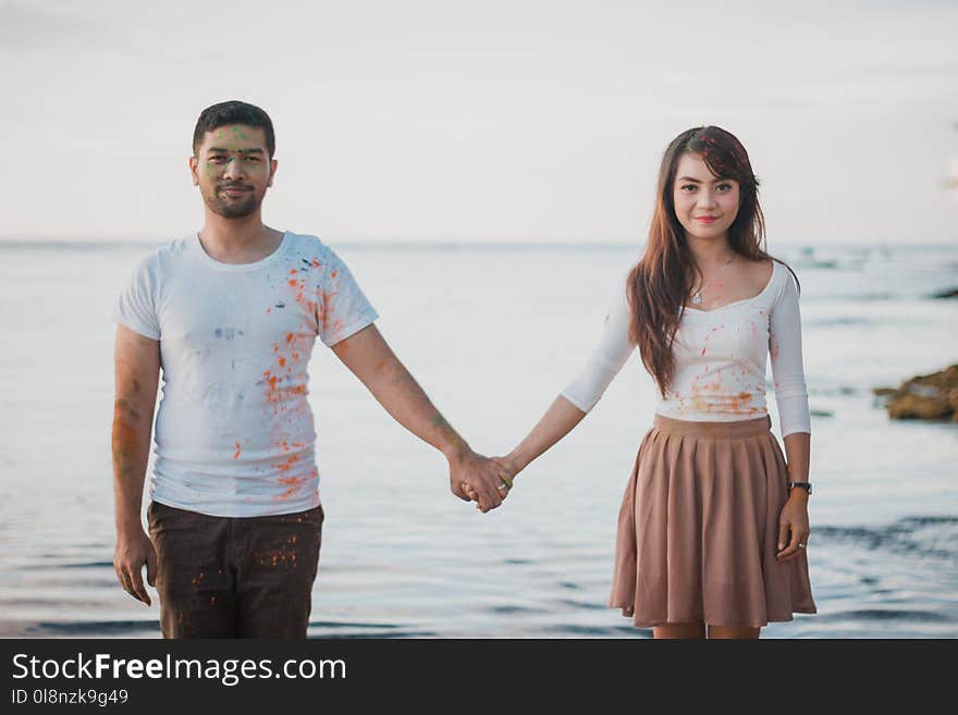 Man and Woman Standing Beside Body of Water