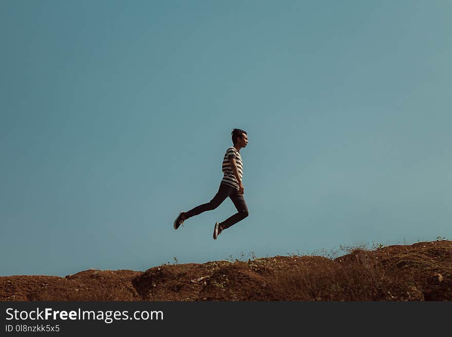 Man Jumping Near the Cliff