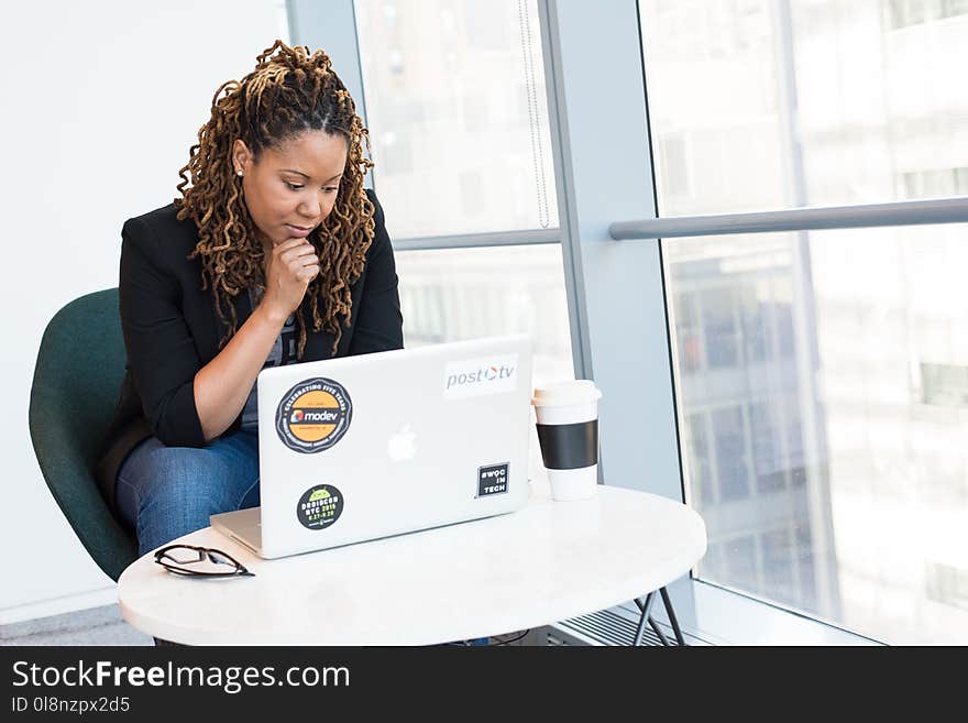 Woman in Black Coat in Front of White Laptop Computer