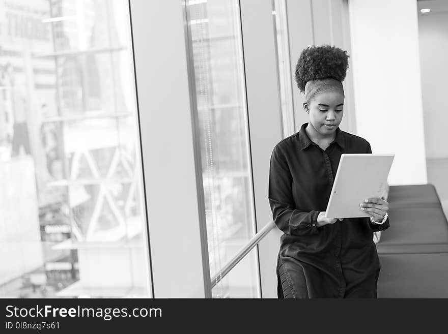 Grayscale Photo of Woman Holding Tablet Computer