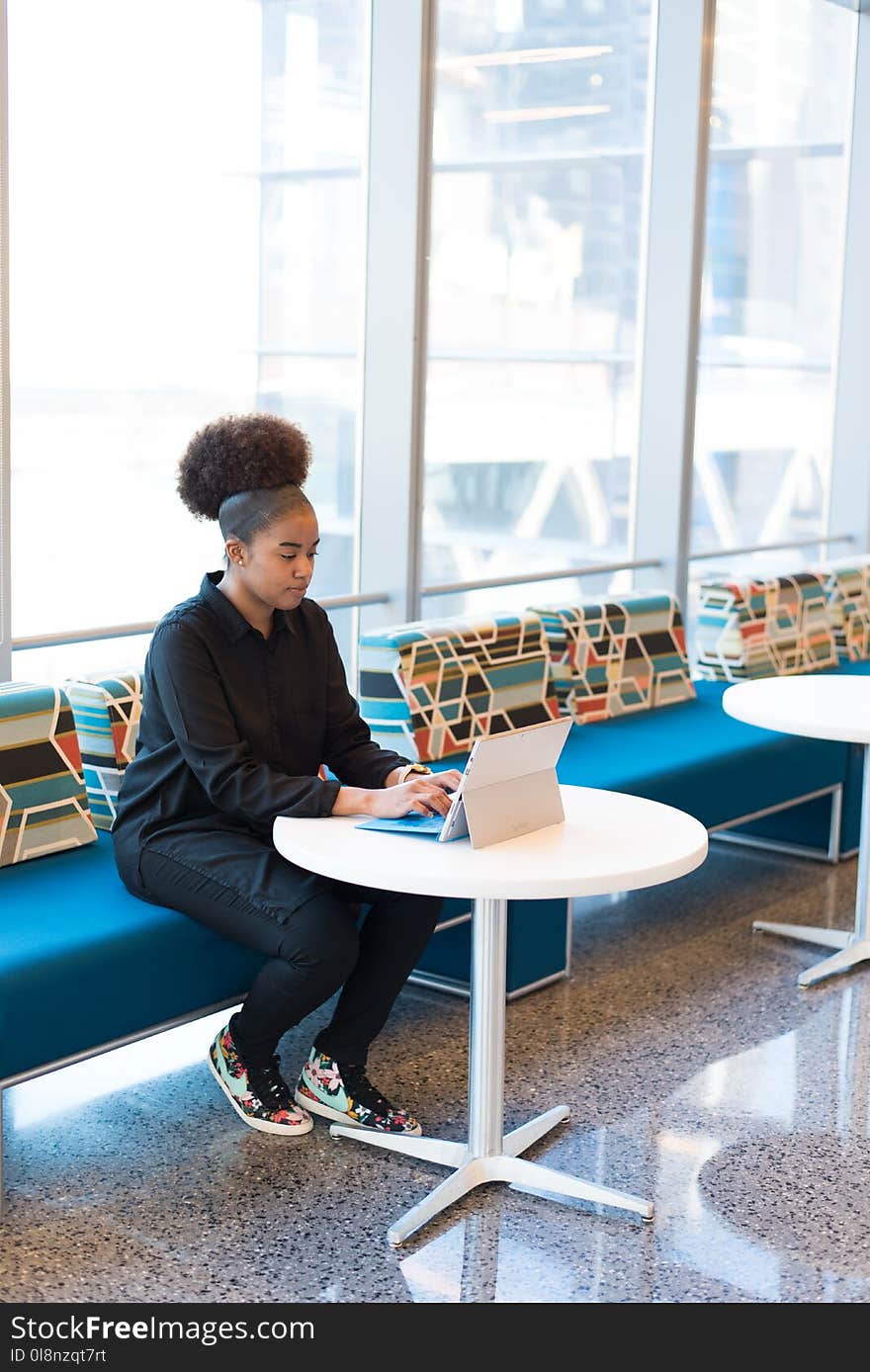 Woman in Black Outfit Working on a Laptop.