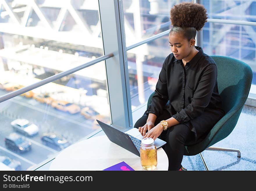 Woman in Black Button-up Top Sitting on Chair