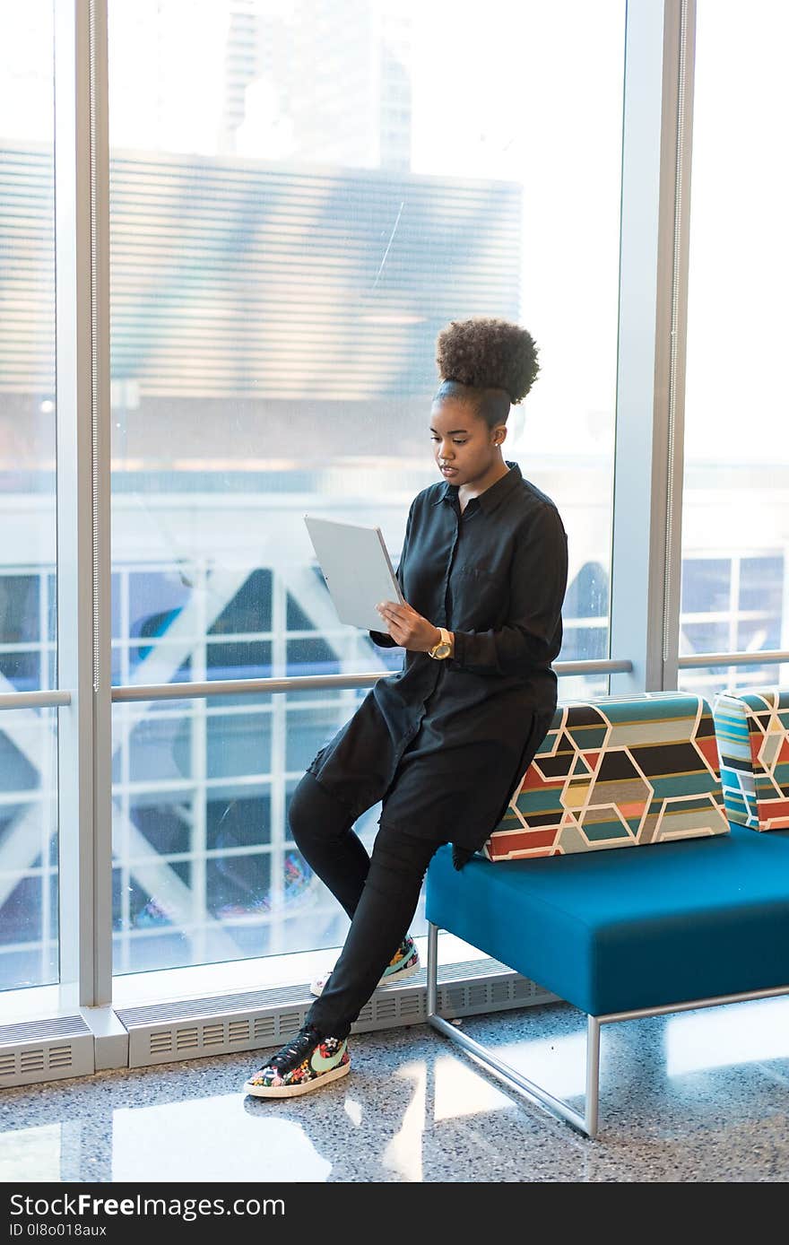 Woman in Black Jacket Standing Near Blue Sofa