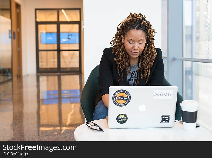 Woman in Black Blazer Sitting on Black Chair Using Laptop