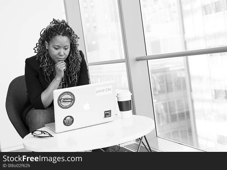 Grayscale Photo of Woman Facing Macbook