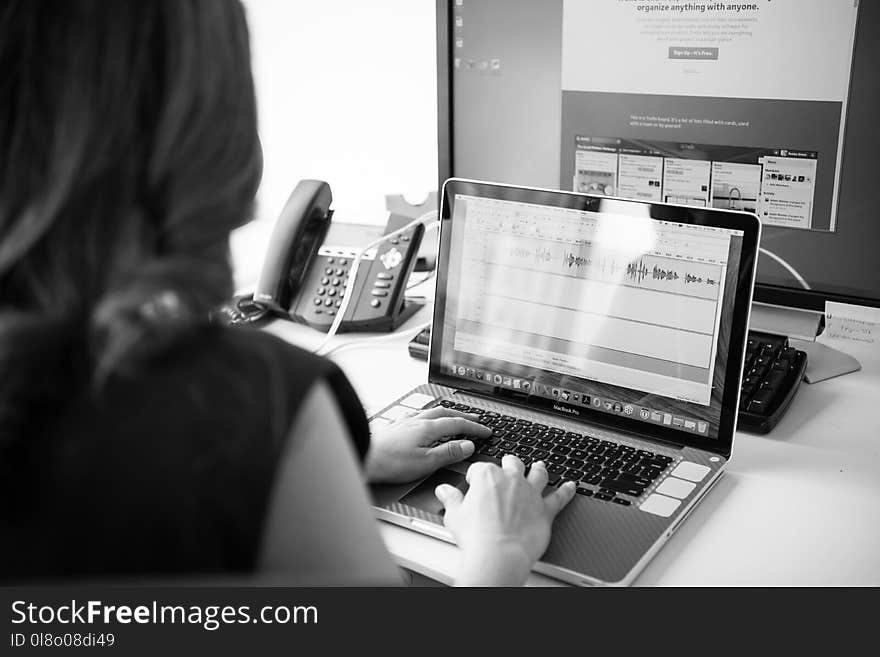 Grayscale Photo of Woman Using Macbook Pro