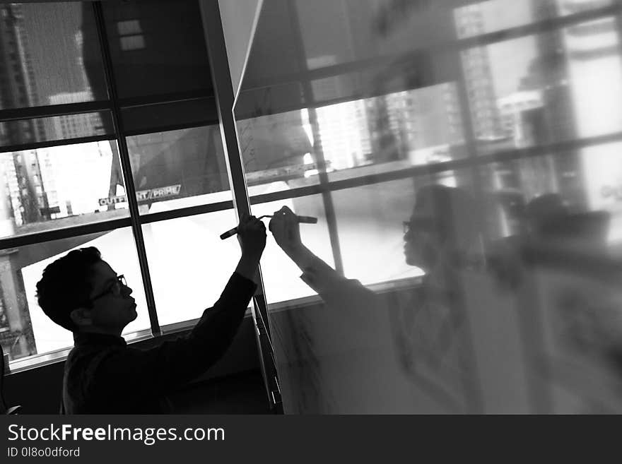 Grayscale Photo of Man Holding Pen