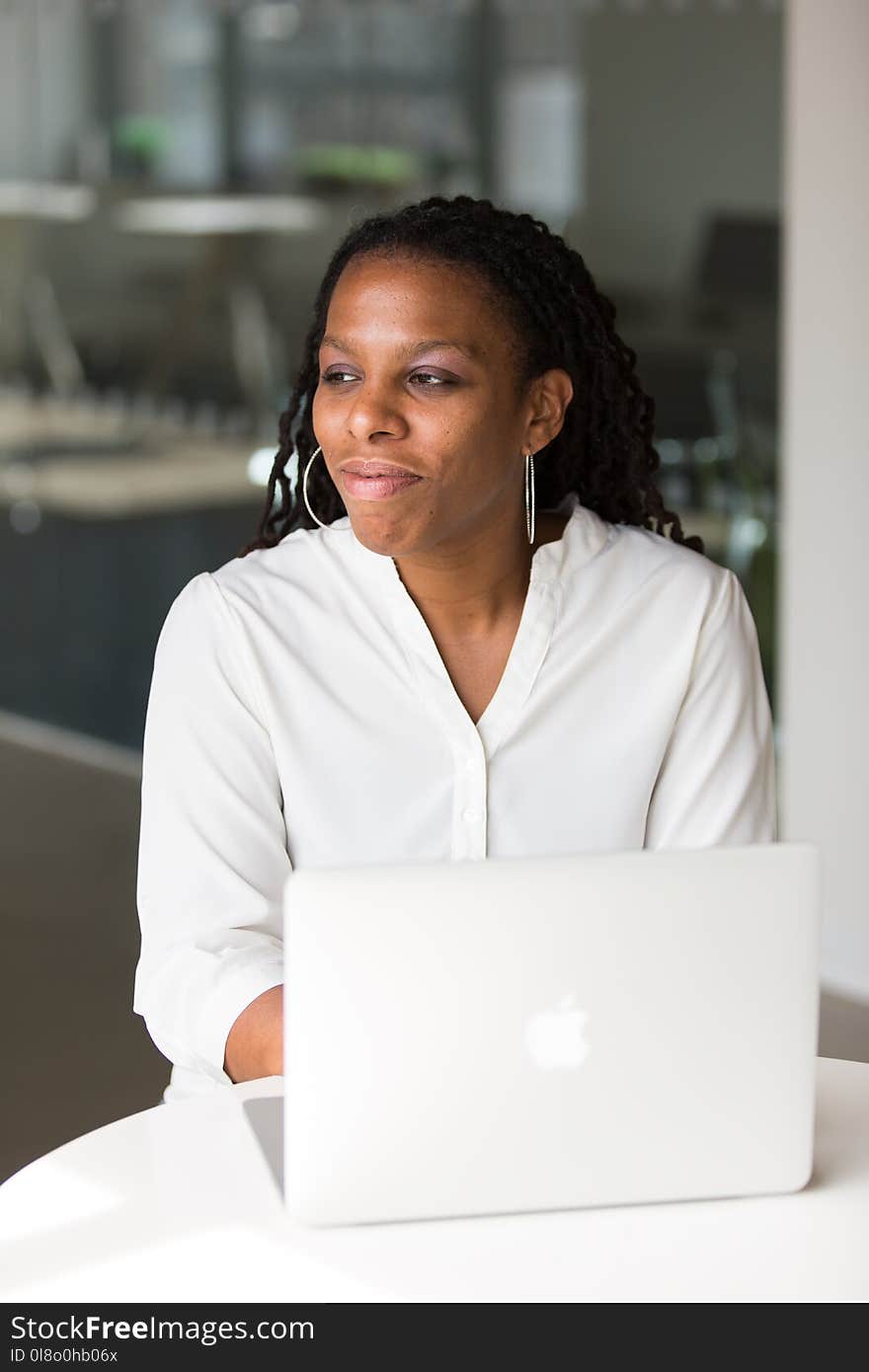 Woman Wearing White Button-up Shirt Sitting in Front of Table