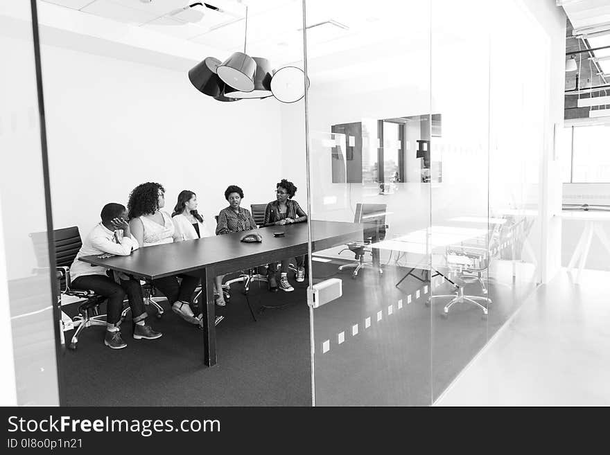 Grayscale Photography of Man and Woman Sitting on Chair