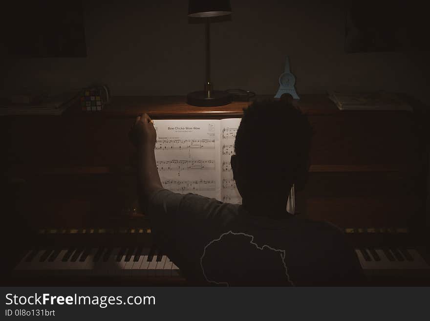 Photo of Person Sitting In Front Of Piano