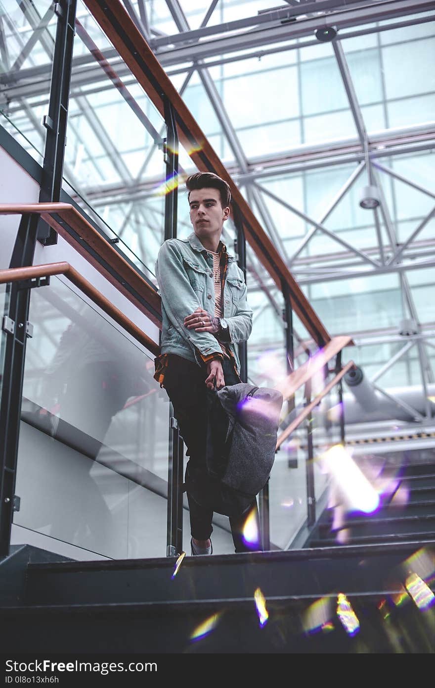 Man in Blue Jacket Standing on Stairs