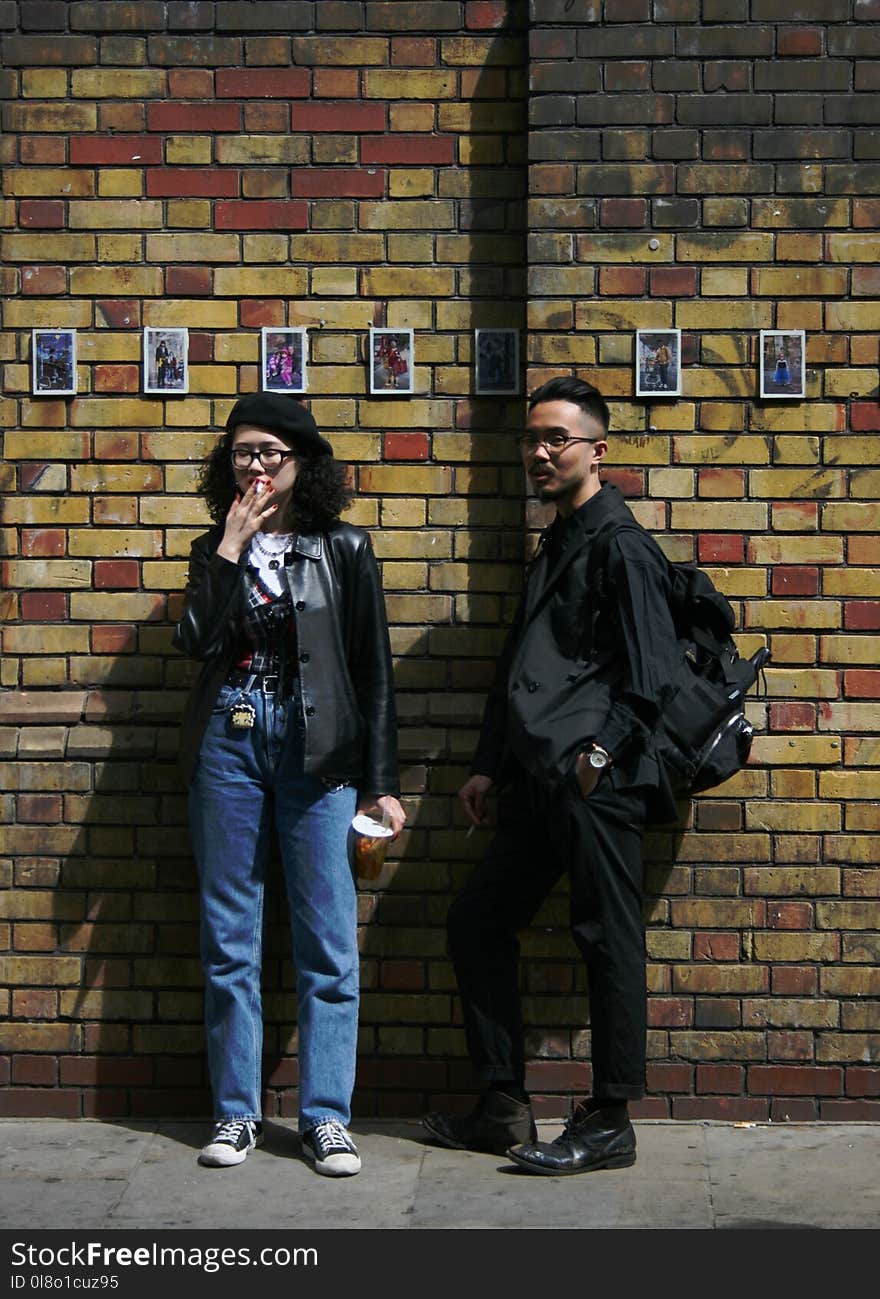 Man and Woman Standing in Front of Concrete Wall