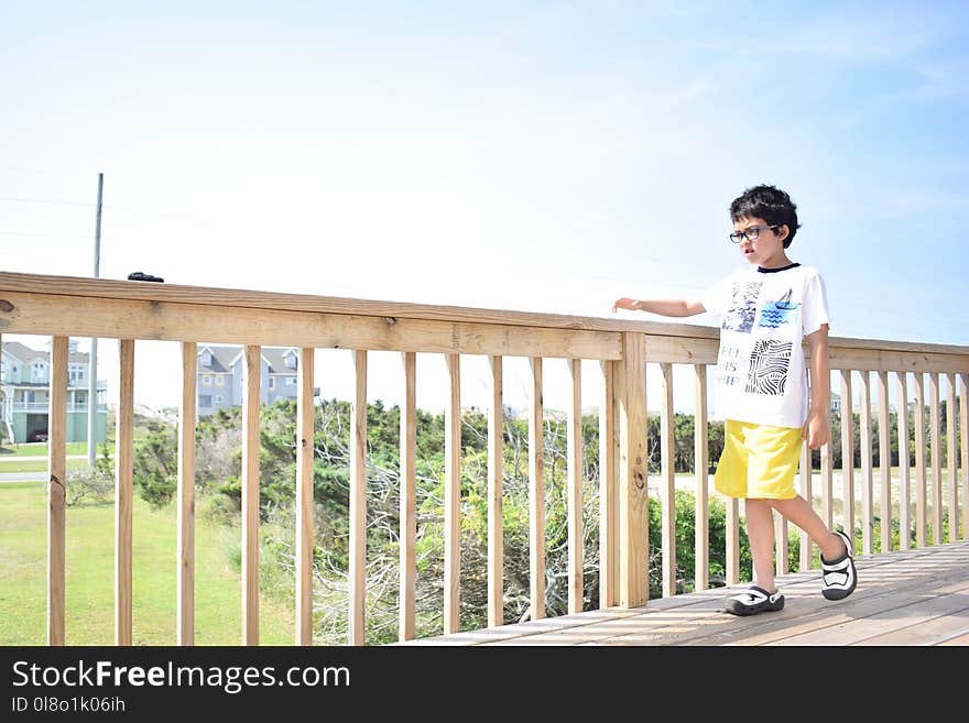 Boy Walking on Wooden Bridge.