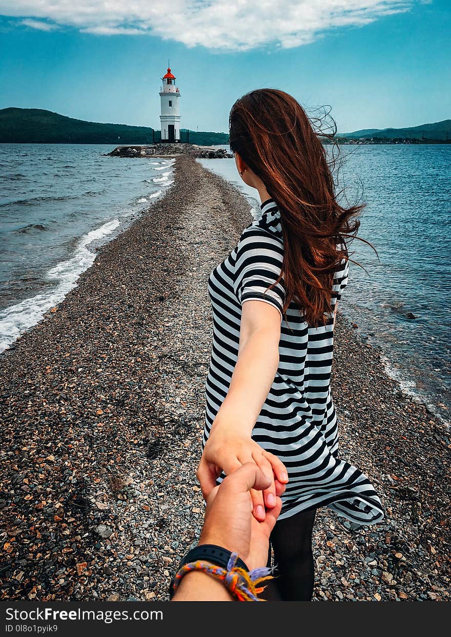 Woman in Stripes Holding Hands With Person Wearing Bracelets