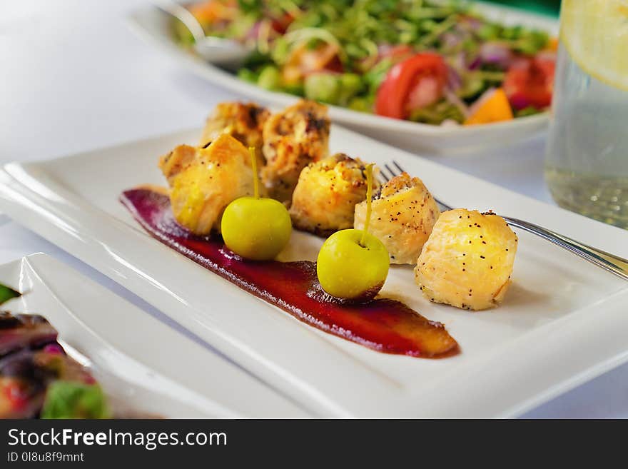 Chicken breast rolls with aples and sauce on a white plate on a table. Close up.