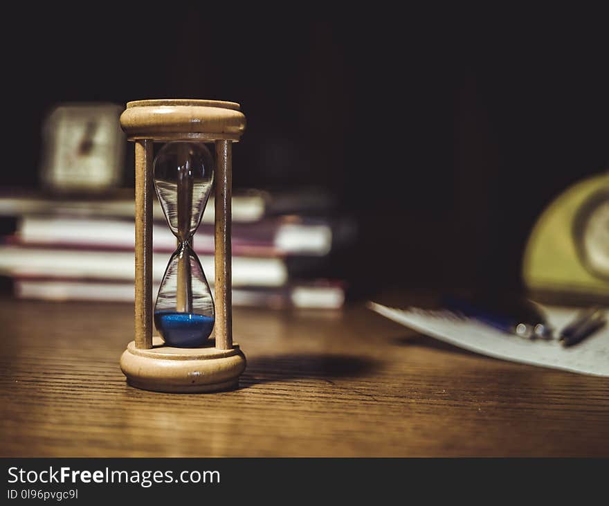 Brown Hourglass on Brown Wooden Table